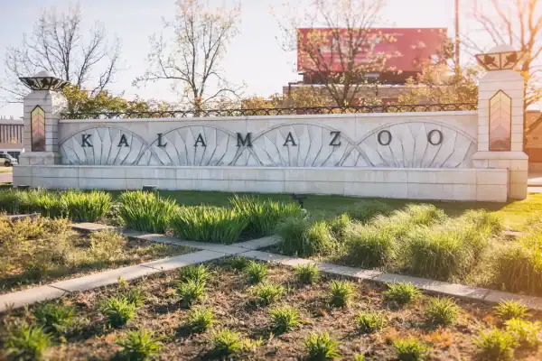 Kalamazoo city entrance sign with landscaped grounds, symbolizing the community and housing market discussed in an investigation of political and landlord power.